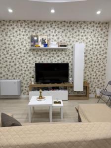 a living room with a tv and a couch and a table at Appartamento il giglio in Terracina