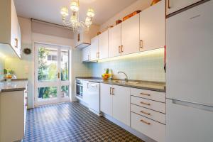 a kitchen with white cabinets and a tile floor at Serralves 1048 Luxury Villa in Porto