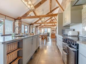 una cocina con armarios blancos y techos de madera. en 3 Bed in Leominster 50517, en Pencombe