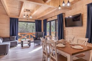 a dining room with a table and chairs and a couch at Harmonia Lasu in Solina +25 photos
