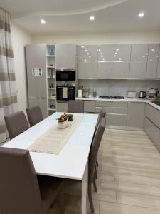 a kitchen with a large white table and chairs at Appartamento il giglio in Terracina