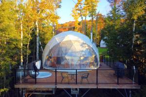 a iguana tent on a deck in a forest at Bel Air Tremblant Hotel & Residences in Mont-Tremblant