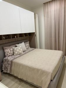a bedroom with a large bed with white cabinets at Appartamento il giglio in Terracina