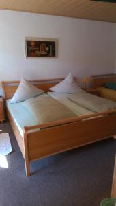 a bedroom with a large bed with two pillows at Ferienweingut Arnold Thiesen in Bruttig-Fankel