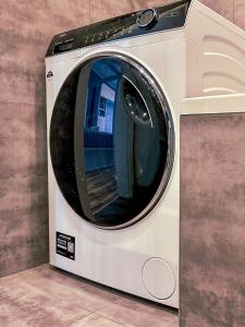 a white washing machine sitting on a floor at Apartment 19 - Aquapark Reda in Reda