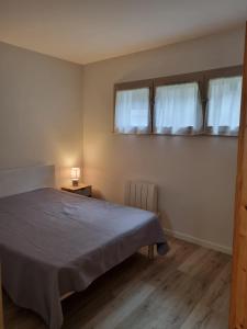 une chambre avec un lit et deux fenêtres dans l'établissement Bel appartement T2, 50 m de la plage des Minimes, La Rochelle,, à La Rochelle