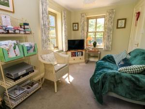 a living room with a couch and a tv at Garden Cottage in Alvescot