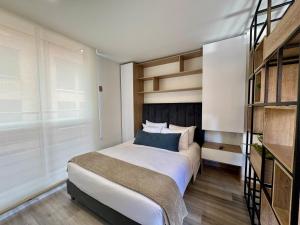 a bedroom with a bed and a book shelf at Cozy Loft in 93 park in Bogotá
