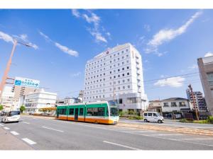 a bus driving down a city street with a building at Orient Hotel Kochi - Vacation STAY 13526v in Kochi