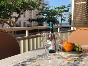 a table with a bottle of wine and wine glasses at Vernisa Apartamento Numero Uno in Playa de Gandia