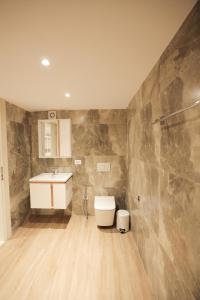 une salle de bain avec toilettes et lavabo dans l'établissement Duplex City, à Durrës 209 autres photos