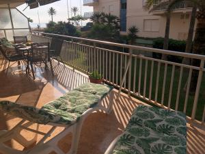 a balcony with two chairs and a table on a balcony at Vernisa Apartamento Numero Uno in Playa de Gandia +45 photos