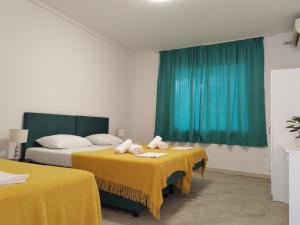 a hotel room with two beds with yellow sheets at Villa Stanović Tea in Cavtat +19 photos