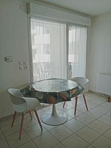 - une table dans une pièce avec 2 chaises et une fenêtre dans l'établissement Le Benvegnu, à Chambéry
