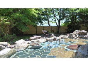 a rock pool with a chair in a yard at Tsujun Sanso - Vacation STAY 11962v in Yamato
