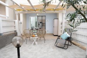 a room with chairs and a table and a refrigerator at Green Villetta with a pool in Viddalba