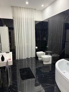 a black and white bathroom with two sinks and toilets at Appartamento il giglio in Terracina +2 photos