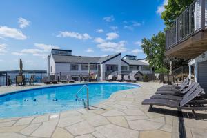 una piscina con sillas y una casa en Lakefront Retreat with Community Pool in Osage Beach, en Osage Beach