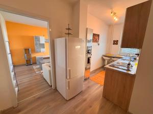 a kitchen with a white refrigerator in a room at Cozy apartment - Excellent location in Piešťany