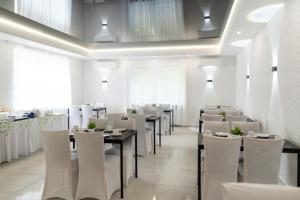 a dining room with tables and white chairs at Damhirsch in Neustadt am Rübenberge