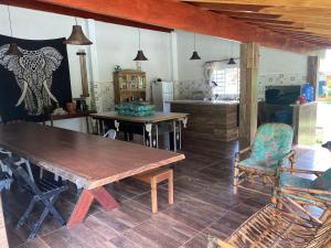 a kitchen with a wooden table and chairs in a room at Chácara Namorada do Sol - Pousada e Camping in Guaxupé