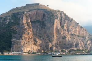 a boat on the water in front of a mountain at Appartamento il giglio in Terracina
