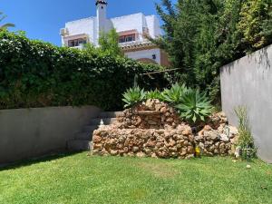 a garden with a stone wall and a staircase at Villa Serena near the beach in Mijas Costa