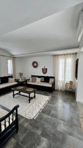 a living room with a couch and a table at Villa Le Domaine Djerba Piscine Chauffée sans vis à vis in Mezraya