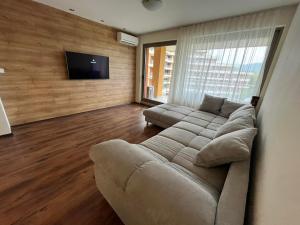 Una sala de estar con un sofá y un televisor de pantalla plana. en Platinum apartment, en Bŭnzareto