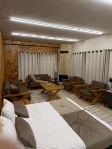 a bedroom with a large bed and chairs and a couch at Oak Farm مزرعة البلوط in Ajloun