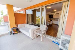 Una sala de estar con un sofá blanco y una silla. en Platinum apartment, en Bŭnzareto