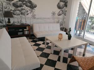 a living room with a white couch and a table at Villa climatisée, proche mer, 2 grands appartements indépendants, parking, WIFI in Le Grau-dʼAgde