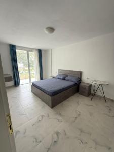 ein Schlafzimmer mit einem Bett und einem Tisch darin in der Unterkunft 9apartaments shengjin in Shëngjin