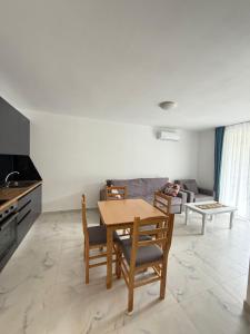 eine Küche und ein Wohnzimmer mit Tisch und Stühlen in der Unterkunft 9apartaments shengjin in Shëngjin