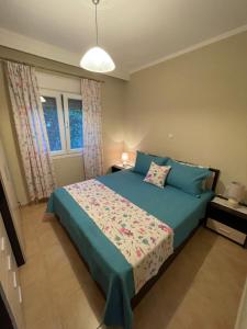 a bedroom with a bed with blue sheets and a window at Olivia apartment in Skala Sotiros