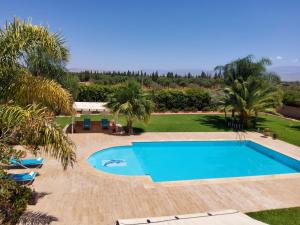 a swimming pool in a resort with palm trees at Villa privée Wafa in Marrakesh