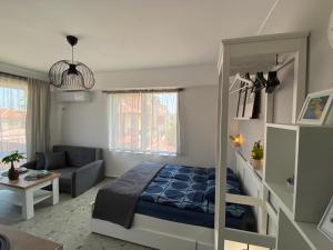 a bedroom with a bed and a couch in a room at Студио Larimar in Lozenets