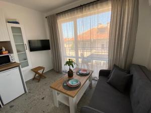 a living room with a couch and a table and a window at Студио Larimar in Lozenets