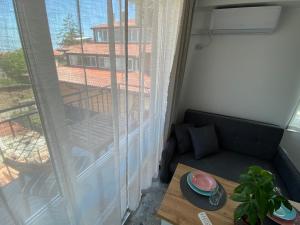 a living room with a couch and a window at Студио Larimar in Lozenets