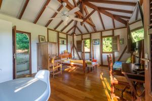 sala de estar con ventilador de techo y mesa en Bungalow Caféière, en Le Carbet