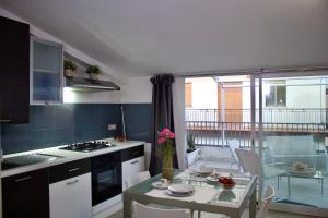 a kitchen with a table and a dining room at Evergreen Terrace in Giardini Naxos