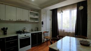 cocina con fogones y mesa con sillas en App, en Itʼkhvisi