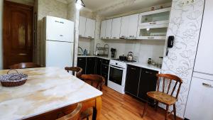 cocina con nevera blanca y mesa con sillas en App, en Itʼkhvisi 3 fotos más