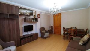 Una sala de estar con televisión y un comedor. en App, en Itʼkhvisi