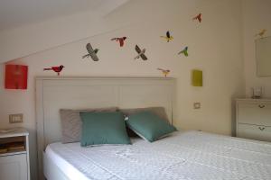 a bedroom with a bed with birds on the wall at Evergreen Terrace in Giardini Naxos