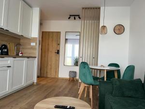 a kitchen and a living room with a table and chairs at Apartament 49 in Toruń +10 photos