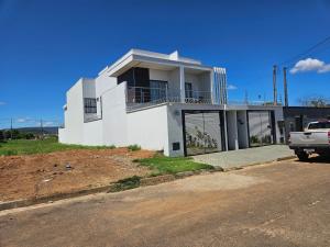 a white house with a truck parked in front of it at Casa Bella com piscina 1504 sul in Santo Antônio