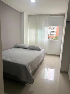 a bedroom with a bed and a window at apartamento 302 alquiler rentahouse in Bucaramanga