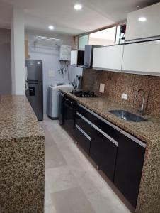 a large kitchen with a sink and a refrigerator at apartamento 302 alquiler rentahouse in Bucaramanga