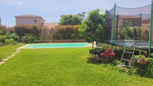 a swimming pool in a yard with plants at Chambre d'hôte dans une maison cosy in Saint-Martin-de-Crau
